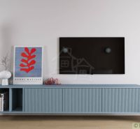 A living room in a cottage with minimalist furniture, a television, and a blue floor lamp.