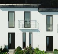 A two-story cottage in Divín with large windows and a balcony, surrounded by greenery.