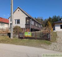 Family house in Kalinovo with wooden cladding, fence, and surrounding nature for sale.