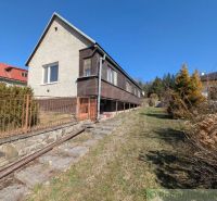 A family house in Kalinovo with concrete stairs and wooden railing on a slope.