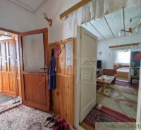 Interior of a family house with corners, shoes on the floor, and wooden wall paneling.