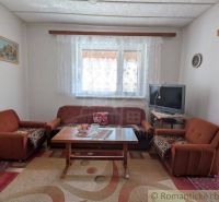 Living room in a family house with a brown sofa and a television.