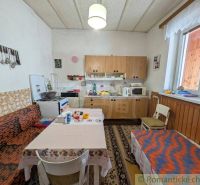 A kitchen in a family house with wooden decor and furniture, comfortable seating at the table.