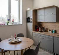 Kitchen corner in offices with a window, wooden decor, and a dining table.