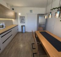 A kitchen in a family house with a wooden decor countertop, table, and floor.