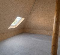 Attic room with OSB boards and a skylight in a family house.