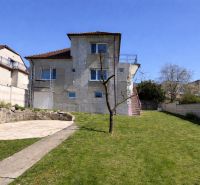 A family house in Koválov with a terrace, garden, and stone elements, unfinished exterior.
