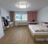 A bedroom in a family house with a wooden decor floor and a comfortable bed.