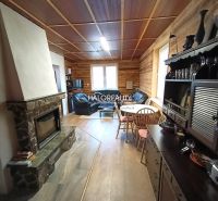 The interior of a cabin with a fireplace, wooden floor decor, and cozy furniture.