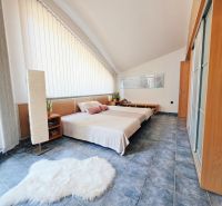 Recreational apartment with a bed, blue floor, light wall, and decorative carpet.