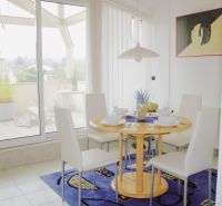 Dining area in a holiday apartment with a view of the terrace.