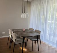 Dining table with chairs, curtains, wooden decor flooring in a 2-room apartment.