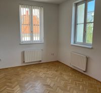 The interior of an office with parquet flooring and windows on Štefánikova Street.