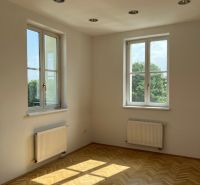 A room with parquet flooring, two windows, and lighting on Štefánikova Street. Suitable for offices.