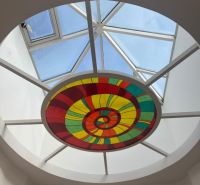 A glass dome with a colorful stained glass design illuminates the space on Štefánikova Street and the offices.