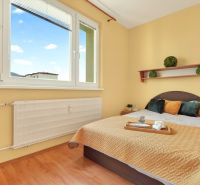 A bedroom with a bed and decorations, a 3-room apartment, floor with wooden decor.
