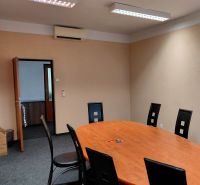 Oval table with black chairs in an office and a carpet.