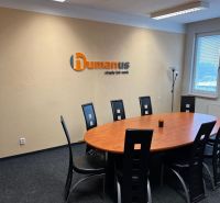 Meeting room with an oval table and black chairs in the office.