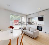 Living room with a kitchen and dining table in a three-room apartment, floor with wooden decor.
