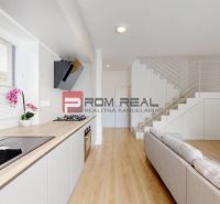 A kitchen in a 3-room apartment with a wood-patterned floor and a counter, staircase in the background.