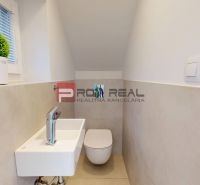 A toilet with a wall-hung WC and a washbasin in a 3-room apartment with a minimalist design.