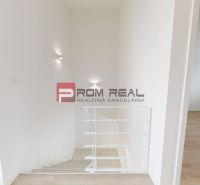 An interior with white walls, a staircase, and a floor with a wooden decor in a 3-room apartment.