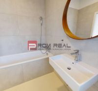 A bathroom with a mirror, bathtub, and sink in a 3-room apartment.