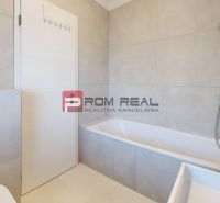 A minimalist bathroom with a bathtub and light tiles in a 3-room apartment.