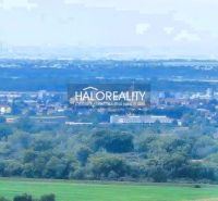 A panoramic view of the landscape around Hlohovec with greenery and a chimney in the background.