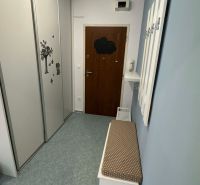 Hallway in a two-room apartment with a wardrobe and a bench with a cushion.
