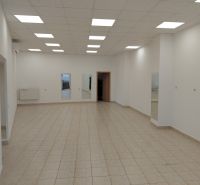 Commercial spaces with tiles, white walls, and ceiling lights.