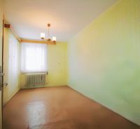 A room in a family house with a simple chandelier and a window radiator.