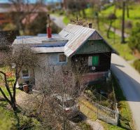 A family house in Petrovce with a garden and a metal roof by a country road.