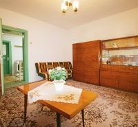 Living room in a family house with wooden furniture and a flower on the table.