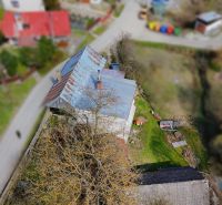 A family house in Petrovice with a metal roof and a garden, surrounded by greenery.