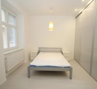 A bright bedroom in a 2-room apartment with a sliding wardrobe and central lighting.