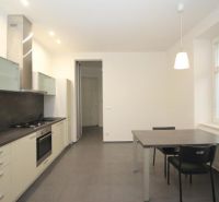 A kitchen in a 2-room apartment with a kitchen unit, dining table, and a large window.