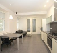 Living room in a two-room apartment with a kitchenette and table, floor with decor.