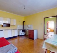 A kitchen in a family house with furniture, a table, and a wooden decor floor.