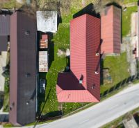 A family house in Dolná Poruba with a red roof and a garden surrounded by houses.