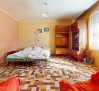 A bedroom with simple furnishings and a wooden decor floor in a family house.