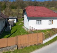 A family house in Dolná Poruba on Dolná Poruba Street with a grassy yard and a metal gate.