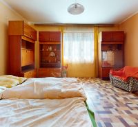 A bedroom in a family house with a wooden decor floor and vintage furniture.
