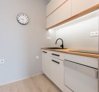 A kitchen in a 2-room apartment with a wooden decor and gray walls.