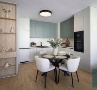 A kitchen in a 2-room apartment with a wooden decor floor, a dining table, and chairs.