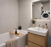 Bathroom in a 2-room apartment with a bathtub, sink, and washing machine, light tiles.