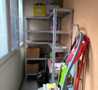 Storage space in a 3-room apartment with shelves and cleaning supplies.