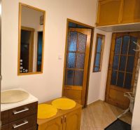 Interior of a 3-room apartment with glass doors and furniture in wood decor.