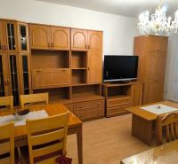 Living room in a 3-room apartment with wooden furniture and a chandelier, floor with wooden decor.