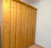 Wooden wardrobe in a 3-room apartment with a wooden decor floor.
